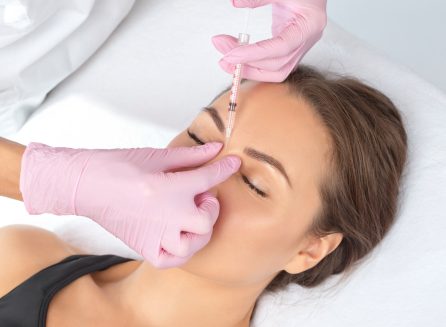 Cosmetologist makes rejuvenating anti wrinkle injections on the face of a beautiful woman. Female aesthetic cosmetology in a beauty salon.